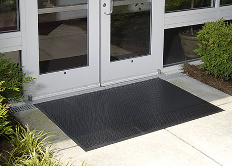 An outdoor scraper mat placed in an entryway